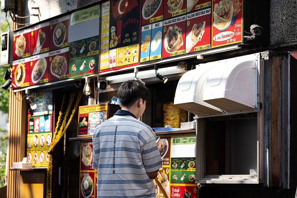 A man ordering kebab from a shop in Tokyo's Okubo district, known for migrant communities including residents from South Korea, South East Asia and South Asia