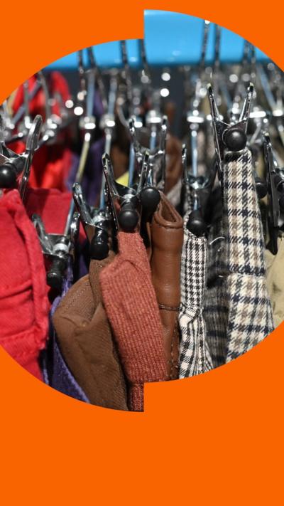 Hangers of donated clothes hanging on a donations rack.