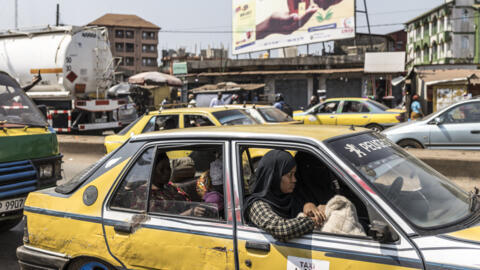 Des passagers assis dans un taxi dans le quartier de Cosa à Conakry, le 26 décembre 2025.