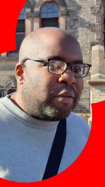 A former prisoner in a grey sweatshirt and glasses