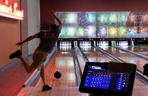 Person bowling with the ball rolling down the lane