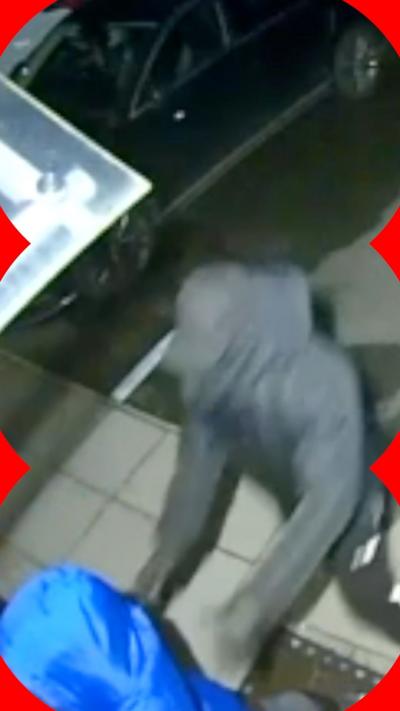 Two people running into a home front door as seen by home security CCTV. The men are entirely covered in black and blue outfits, hoods, gloves and masks.