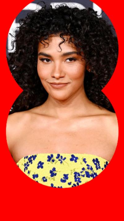 Olivia Dean smiles at a red carpet