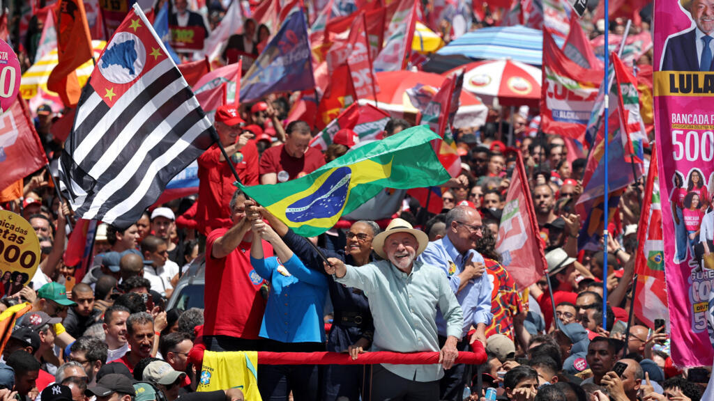 Brazilian President Luiz Inacio Lula da Silva, the Workers' Party (PT) candidate for presidential re-election, holds a flag during a closing campaign rally, one day before the general election.