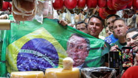 Brazilian presidential candidate Flavio Bolsonaro holds a Brazilian flag depicting his father, former president Jair Bolsonaro, at a campaign rally in Sao Paulo, Brazil, September 28, 2026. 