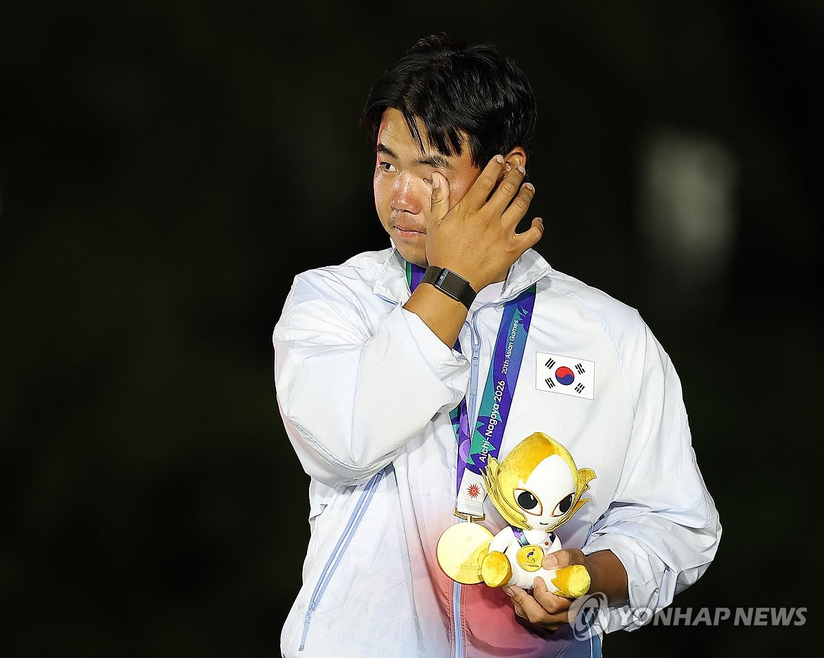 Kim Joo-hyung of South Korea wipes away tears during the medal ceremony of the men's golf tournament of the Aichi-Nagoya Asian Games after winning gold in the individual competition at Kasugai Country Club East Course in Kasugai, Japan, on Oct. 3, 2026. (Yonhap)