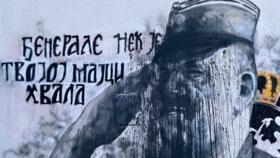 A picture taken in Belgrade on November 15, 2021 shows a mural, vandalized with black paint, depicting former Bosnian Serb military chief Ratko Mladic