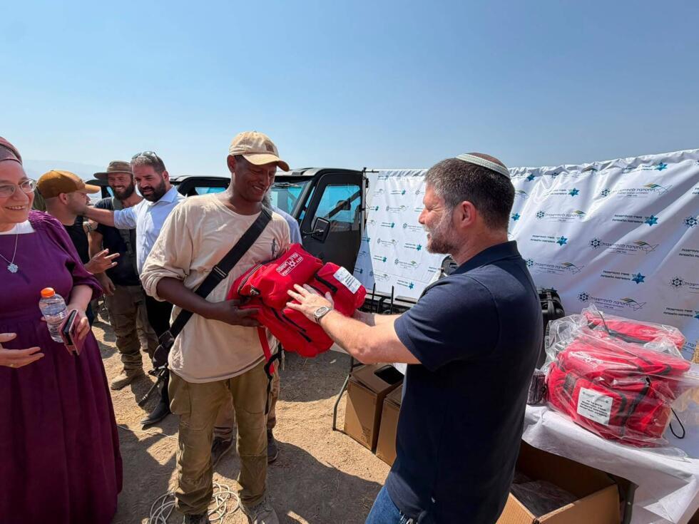 Israeli Finance Minister Bezalel Smotrich hands over a bag of first-aid supplies during a ceremony to hand out “safety equipment” in the illegal settlement of Zarzir Farm on July 6, 2026.