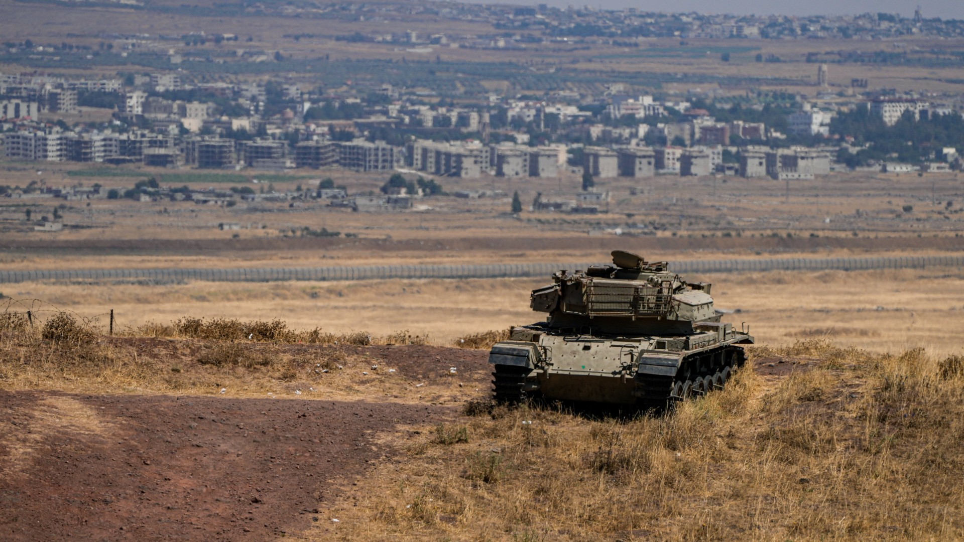 An Israeli tank stands in position near the ceasefire line between the Israeli-occupied Golan Heights and Syria, 20 August 2026 (Ayal Margolin/Reuters)