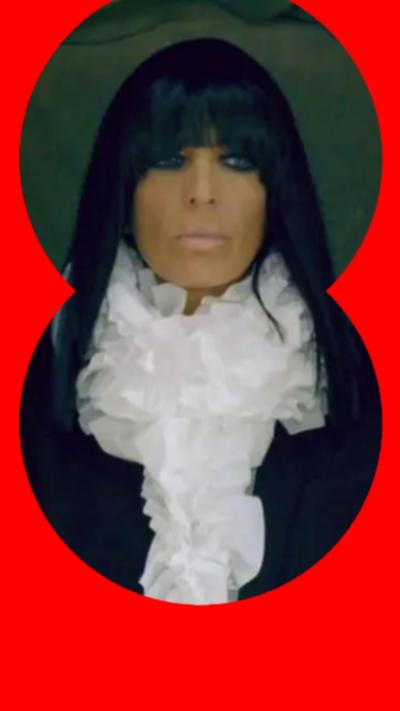 A woman with black hair and a heavy fringe looks at someone off-camera