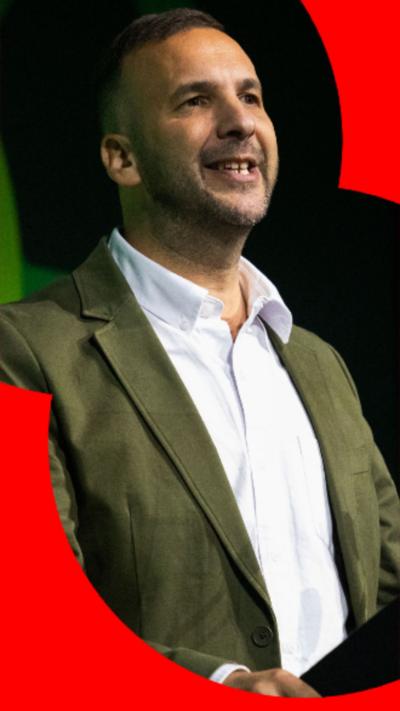 Green Party leader Zack Polanski wearing a green suit jacket and a white top.