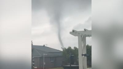 A tornado passes through a residential area.