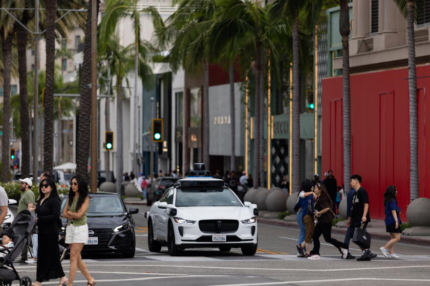 Los Angeles, CA - July 12, 2026: A Waymo car drives down Rodeo Drive in Beverly Hills on Sunday, July 12, 2026, in Los Angeles, CA. Waymo, self driving cars, currently operate in a 79 square mile service area in LA. (Arwen Clemans/Los Angeles Times)