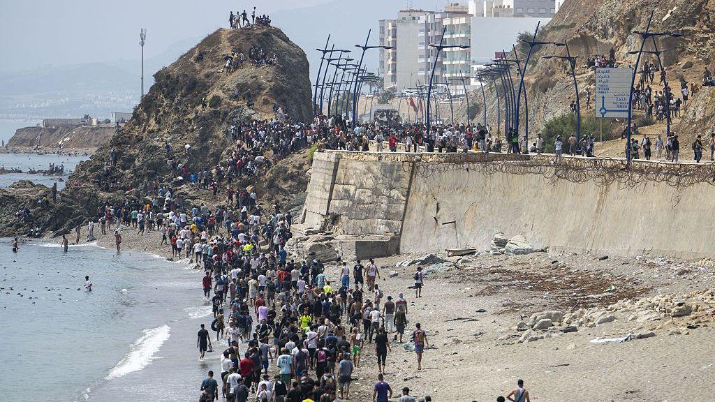 A queue of dozens of people, mostly men, on the shore of Ceuta 