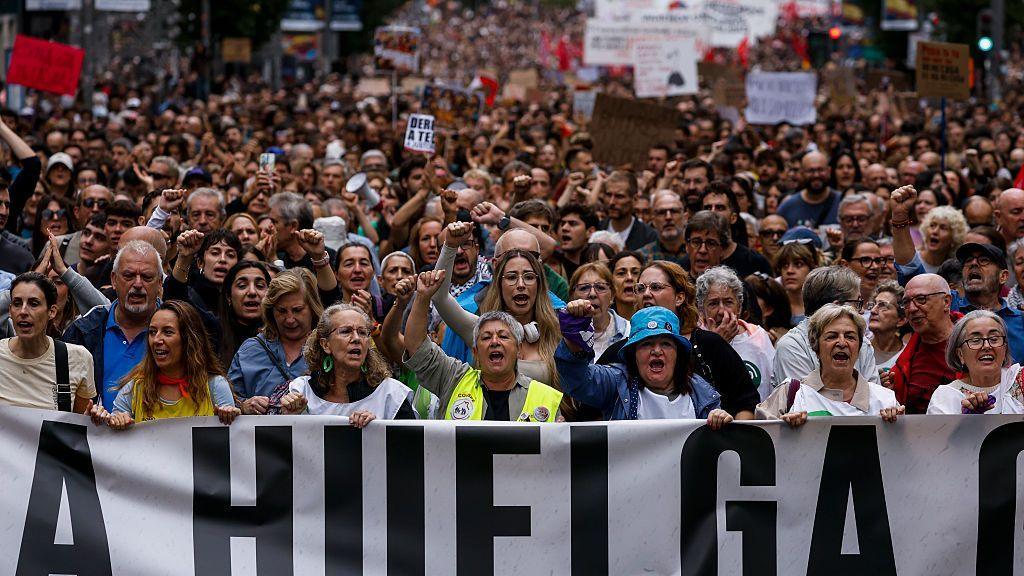 Hundreds of people protest on Madrid's central street of Gran Via, with dozens of women holding a sign which says "towards the general strike"