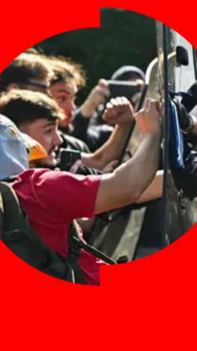 Students bang against shields held by riot police.