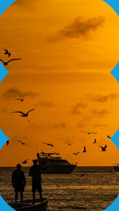 Boats on water under an orange sky