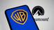 In this photo illustration, the Warner Bros. logo appears on a cell phone with the Paramount logo in the background in Creteil, France, on December 10, 2025. In this photo illustration, the Warner Bros. logo appears on a cell phone with the Paramount logo in the background in Creteil, France, on December 10, 2025.