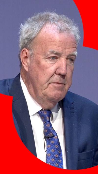 Jeremy Clarkson wearing blue suit, white shirt and blue tie