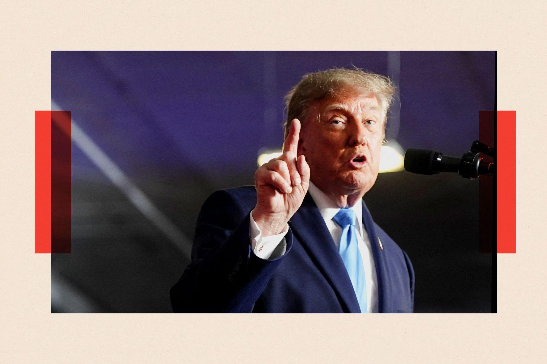 US President Trump holds a finger up at a rally