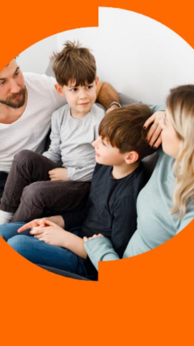 Two children and two adults sit on a couch