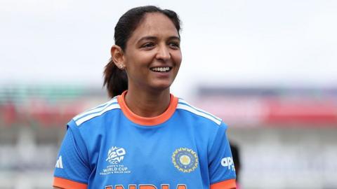 Harmanpreet Kaur of India wearing a blue jersey with orange details reacts at the coin-toss