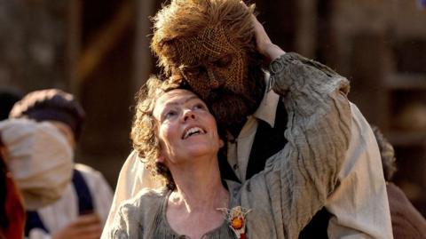 A picture of Olivia Colman as a fisherwoman, hugging Alexander Skarsgård as the Wicker husband in the film "Wicker"