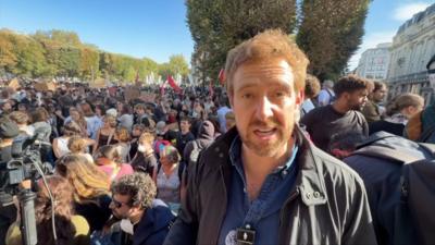 Nick Beake stands in front of a large crowd in Lille