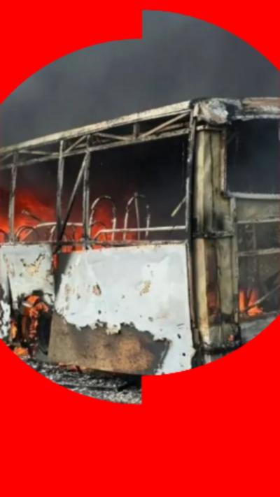 The shell of a bus in flames.