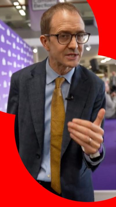 Chris Mason wears a blue jacket and yellow tie
