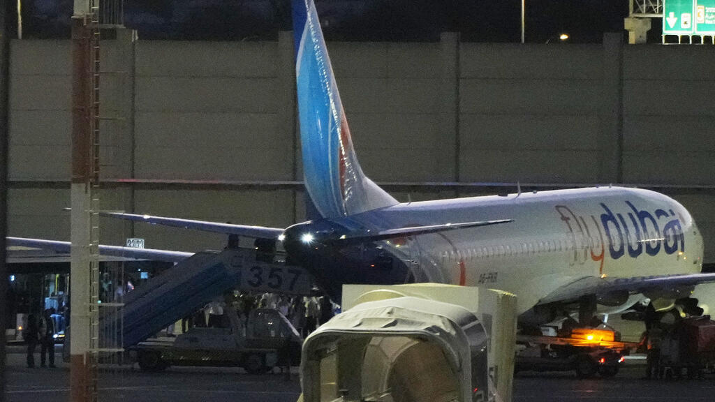 People disembark from a FlyDubai carrying Israeli passengers who had earlier been aboard another FlyDubai aircraft that made an emergency landing in Saudi Arabia approaches Ben Gurion International Ai