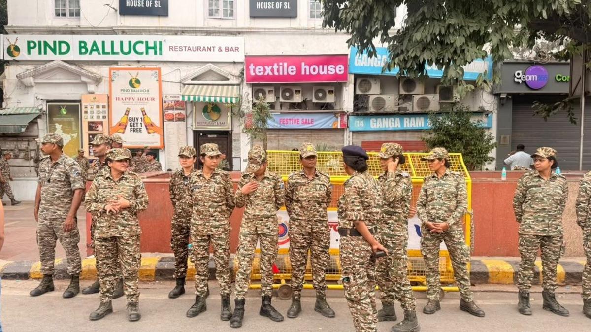 Paramilitary forces stand outside shops in Connaught Police in central Delhi
