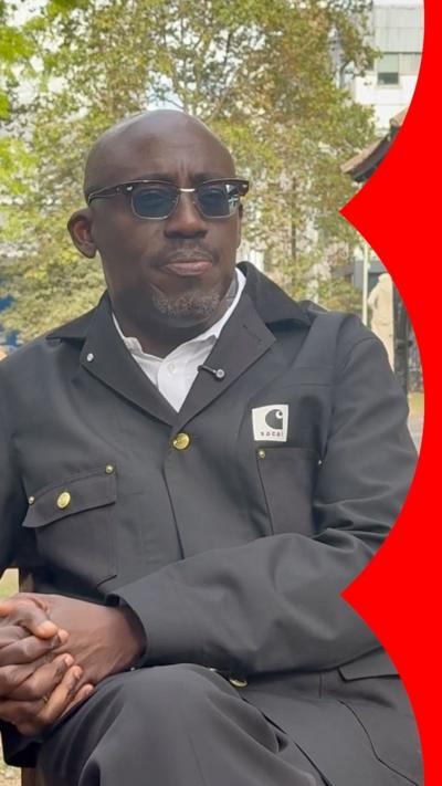 Man wearing black sunglasses, black jacket and white shirt