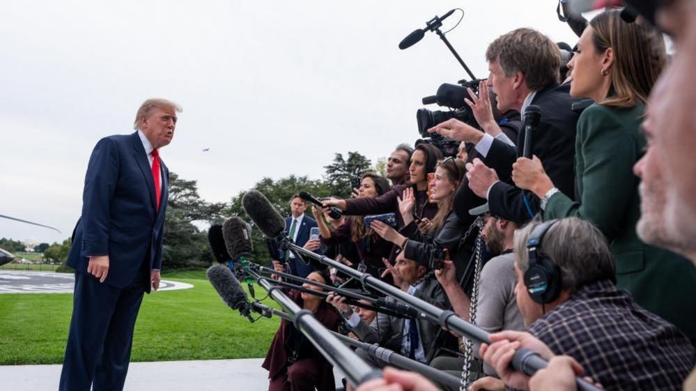 Donald Trump speaks to a large media scrum