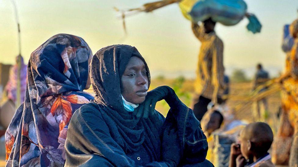 Displaced women rest, one seen with her head resting on her hand, in the town of Tawila after fleeing el-Fasher following the city's fall to the Rapid Support Forces (RSF) - October 2025.