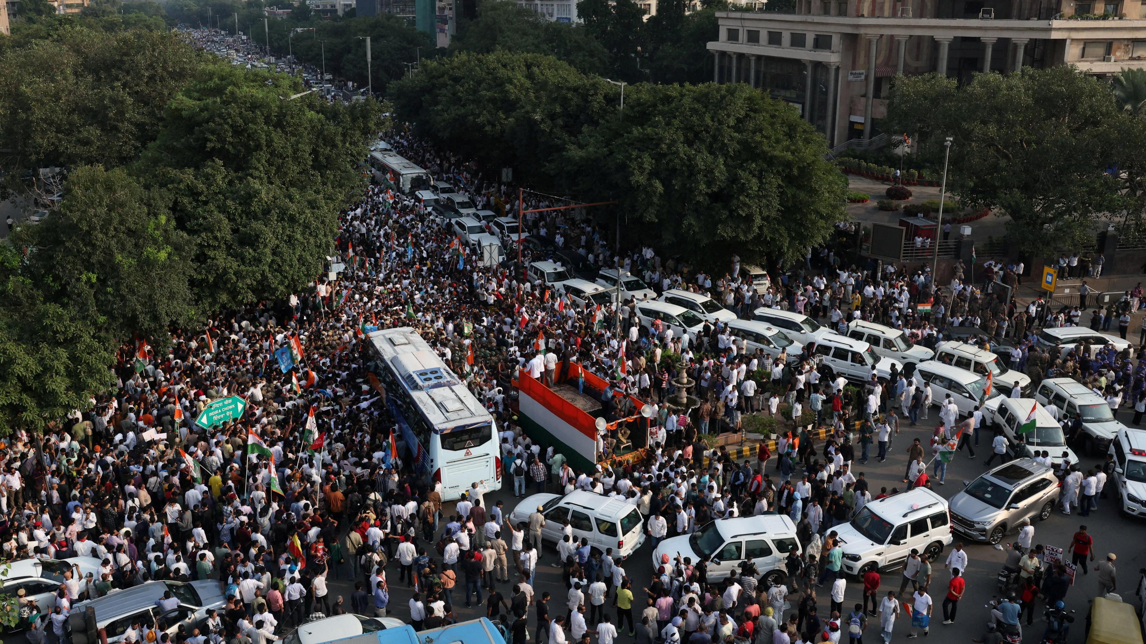 A crowd of people and vehicles gather in the street