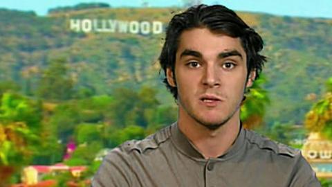 RJ Mitte sitting inside a studio with the Hollywood sign in Los Angeles behind him.