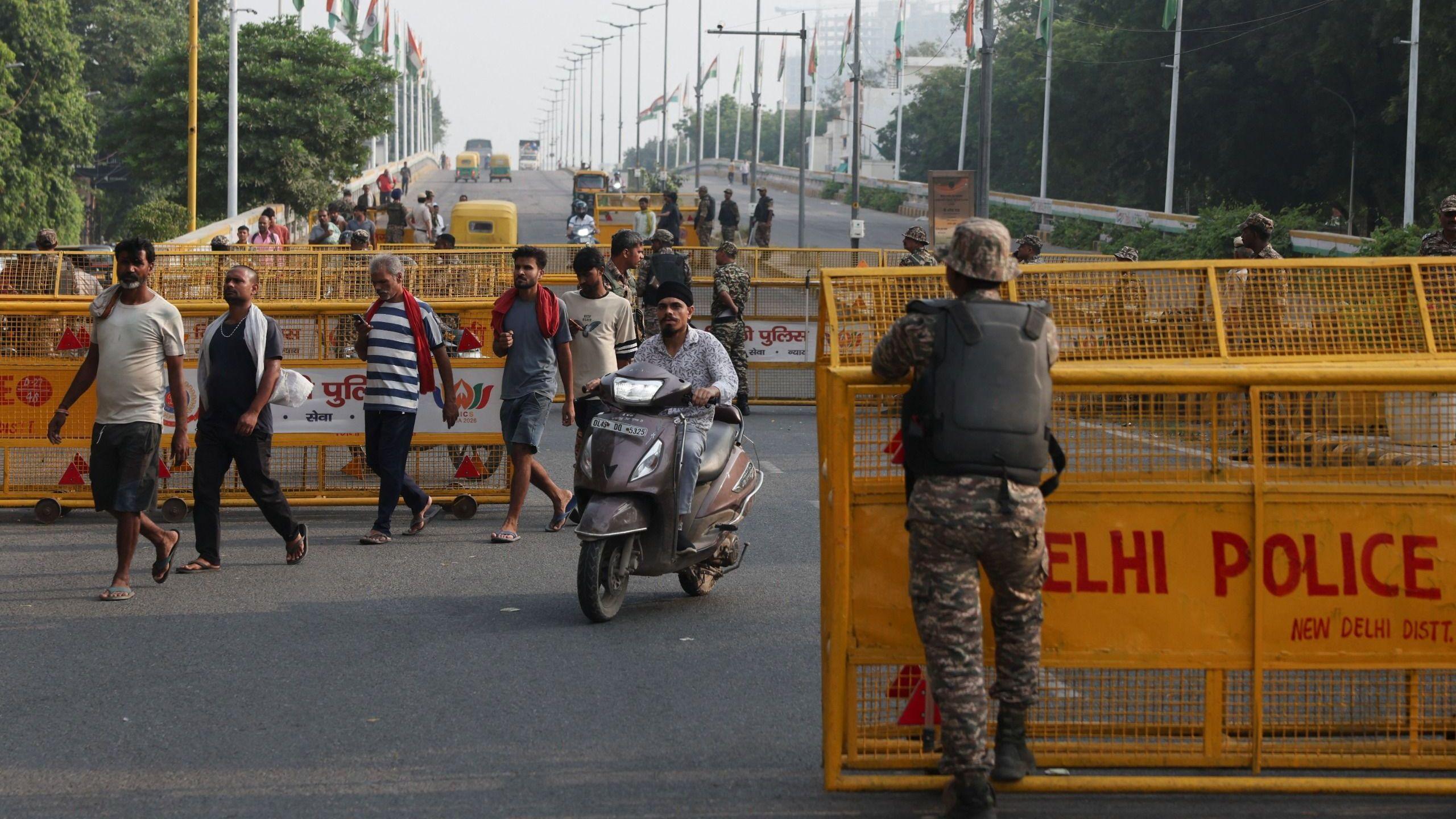 Commuters cross a checkpoint as police officers stand guard on the second day of a protest planned by the Cockroach Janta Party (CJP) seeking the resignation of India's Chief Election Commissioner, Gyanesh Kumar, in New Delhi, India, October 11, 2026.
