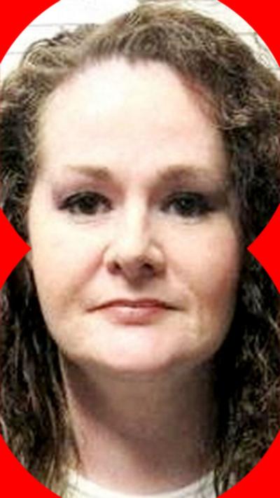 Christa Pike stood in a mugshot room with curly ginger hair.