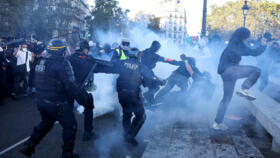 Police officers in riot gear clash with demonstrators during nationwide protests in Paris.
