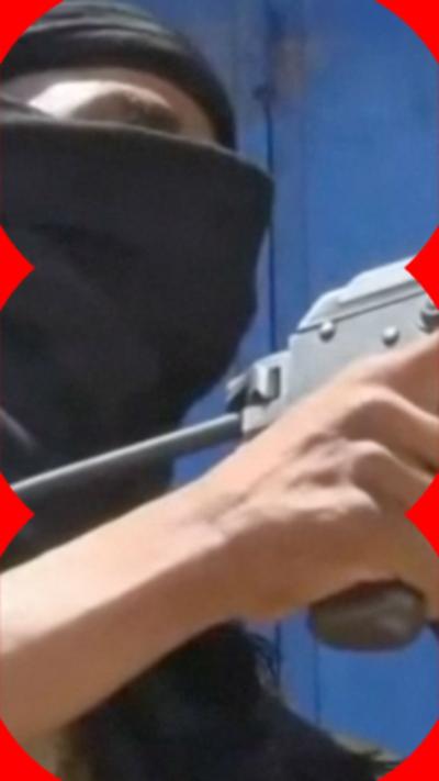 A person wearing a balaclava and holding a machine gun.