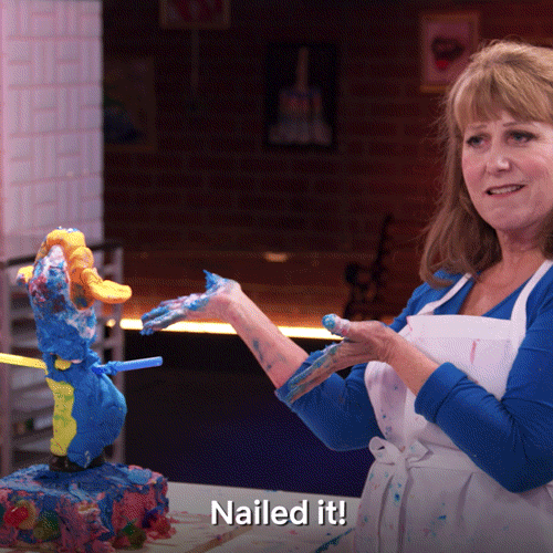 A woman presents a lopsided cake with the words “Nailed it!”