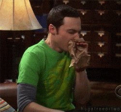 Sheldon breathing into a paper bag.