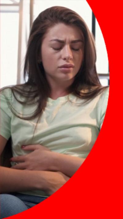 A woman with long brown hair hugs her stomach
