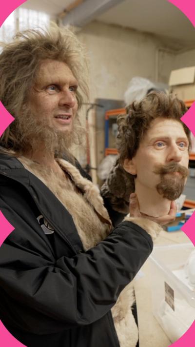 A man with a scruffy beard and hair holds a model of a human head