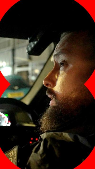 A police officer looking out of the front of a car.
