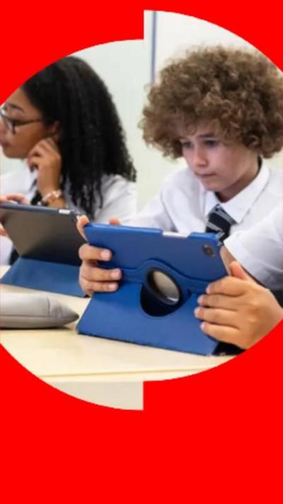 School children sat at their desk, each looking at a computer tablet.