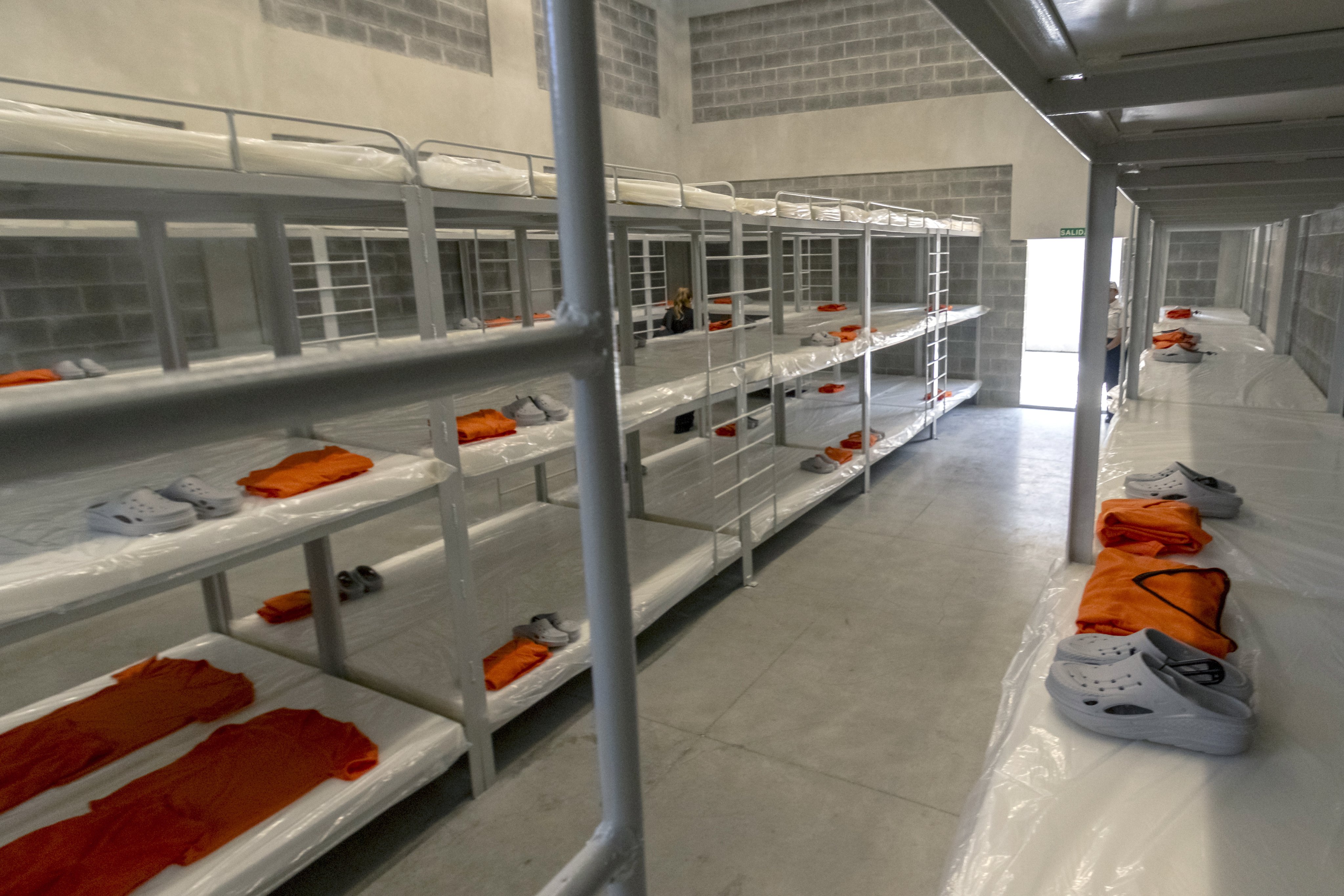 Tiered metal bunk beds with orange inmate uniforms and shoes laid out inside Costa Rica’s new 5,100-capacity mega-prison. Photo: EPA
