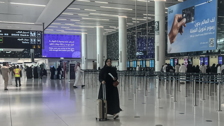 A traveller rolls her suitcase through the departure terminal of King Khalid International Airport in Riyadh on April 2, 2026. 