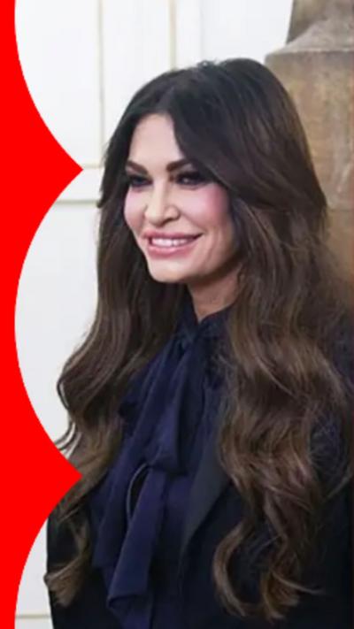 Kimberly Guilfoyle has long dark hair and is wearing a blue top.